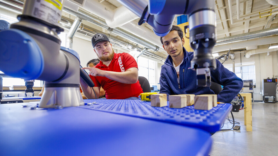 Jacob Hansen, with ALA Engineering and a Nebraska alumnus, and Kunjan Theo Joseph, with the UNL MAARS Lab, work at making their robotic arm program stack blocks at Nebraska Innovation Studio. The programming would simulate a larger robotic arm stacking pallets. 