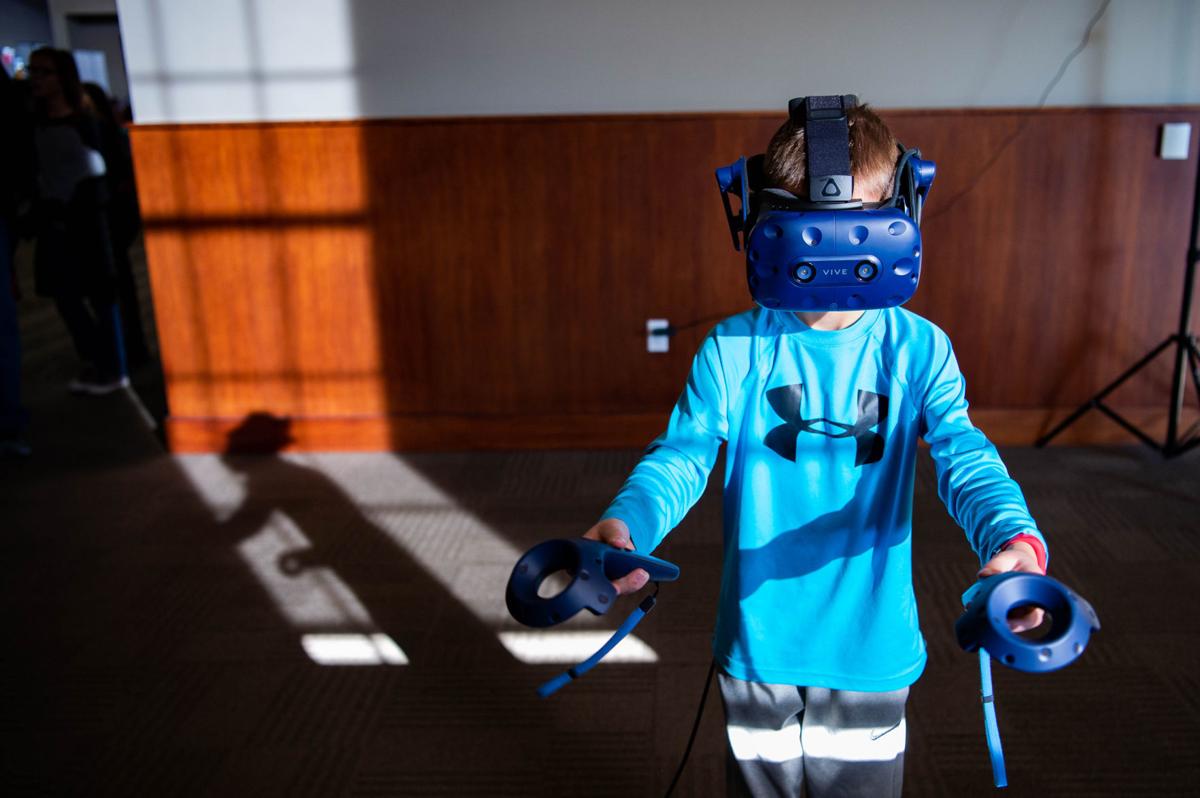 Eight-year-old Callan Scribner completes tasks at a virtual-reality station at the Hour of Code event Saturday, December 8 at the Innovation Campus Conference Center. 