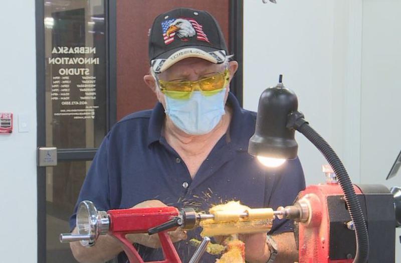 A veteran turns a pen on a midi lathe at Nebraska Innovation Studio.