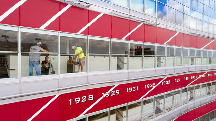 An installation crew from Glass Edge installs new window systems in the club suites of west Memorial Stadium. The windows were designed by Chad Bloomquist, who utilized resources available at Nebraska Innovation Studio to turn his idea into reality. 