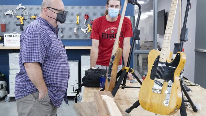 Phil Whitmarsh (left) and Broderick Fielding, who both make guitars, talk about their instruments during an open house at Nebraska Innovation Studio on Thursday. Photo: Gwyneth Roberts, Journal Star