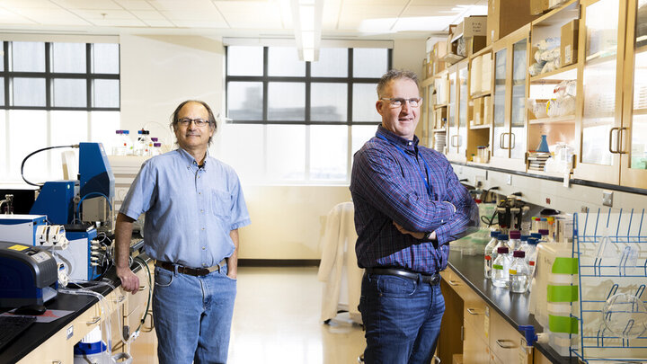 Robert Hutkins and Andy Benson are photographed in the Nebraska Food for Health Center. This image is a composite so the two researchers could appear in one photo without masks. 
