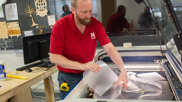 Jerry Reif, shop manager at Nebraska Innovation Studio, works on a laser to cut clear plastic sheeting for face shields. The face shields are being assembled for hospitals in Nebraska in response to COVID-19. 