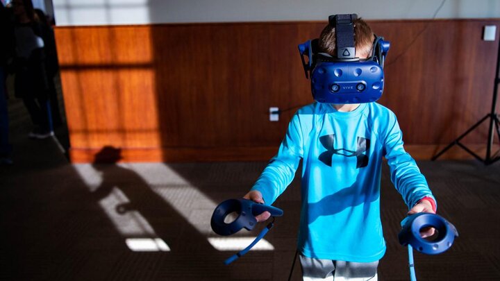 Eight-year-old Callan Scribner completes tasks at a virtual-reality station at the Hour of Code event Saturday, December 8 at the Innovation Campus Conference Center. 