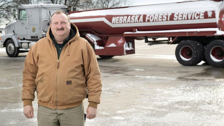 Lew Sieber, manager of the Nebraska Forest Service Fire Shop, with the tank truck he used to haul 200,000 gallons of ethanol across the state to be mixed into hand sanitizer.