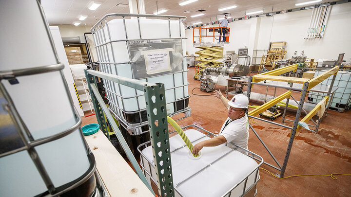 Jan tenBensel, chairman of the Nebraska Ethanol Board, directs Russell Parde as nonflammable ingredients are mixed inside the Food Innovation Center. The ingredients are mixed with the ethanol under stringent safety rules. Hand sanitizer is being made at Nebraska Innovation Campus through a collaboration between the Food Innovation Center and the Nebraska Ethanol Board.