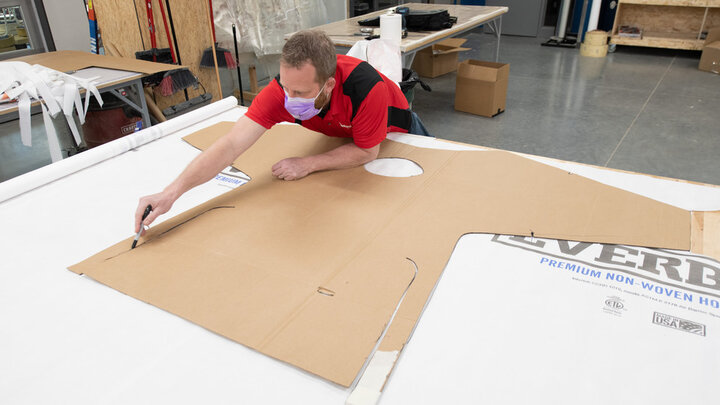 Jerry Reif, studio manager at Nebraska Innovation Studio, cuts out a gown form from Tyvec material.